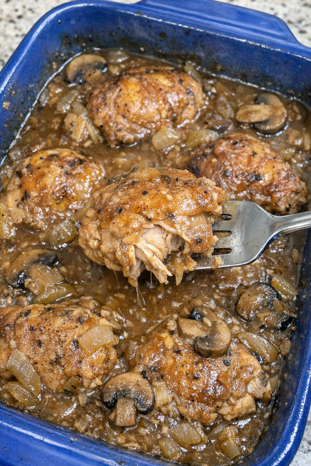 Juicy chicken thighs with onions and mushrooms in brown gravy