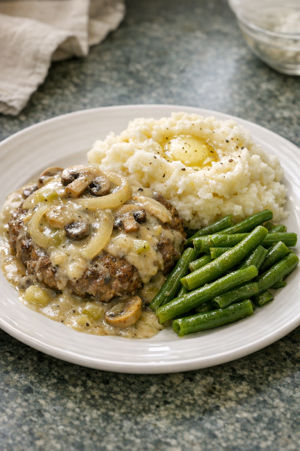 Finished slow cooker beef patties with creamy celery gravy on a serving plate