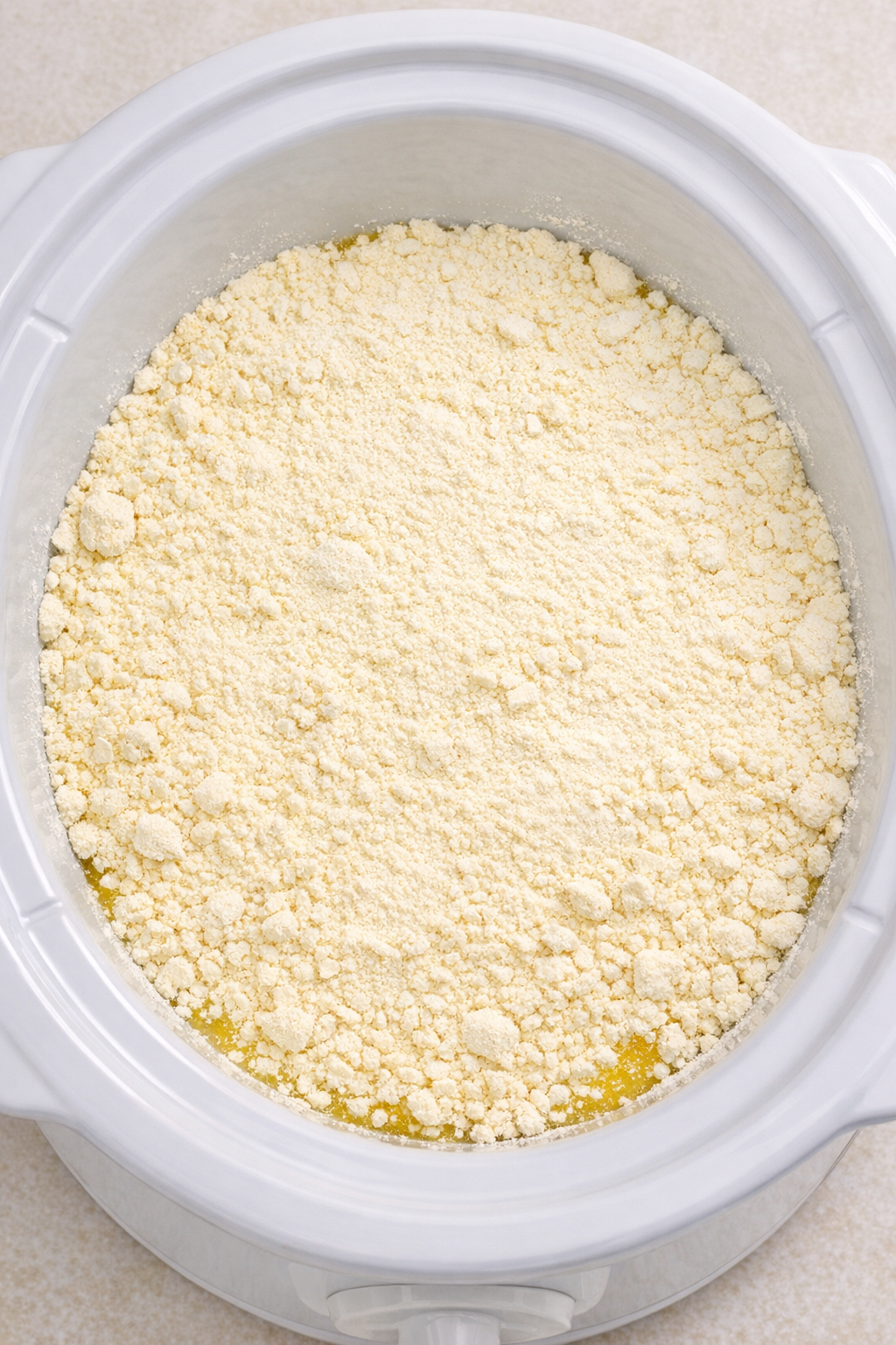 Dry lemon cake mix layered over lemonade concentrate