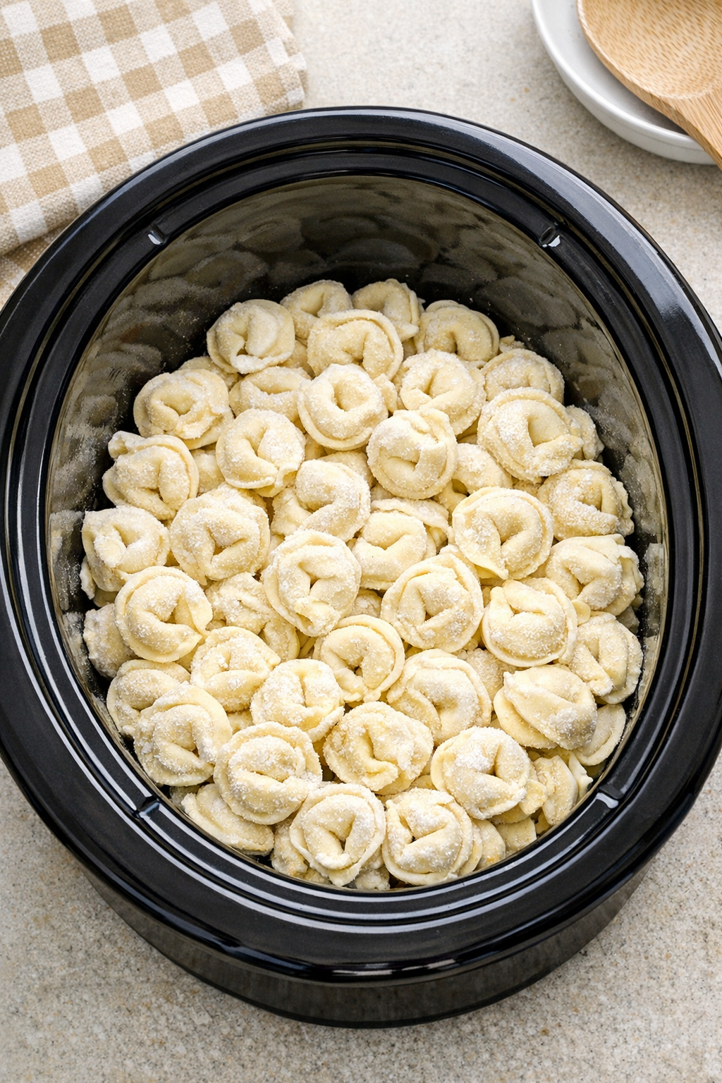 Frozen tortellini in the bottom of a slow cooker