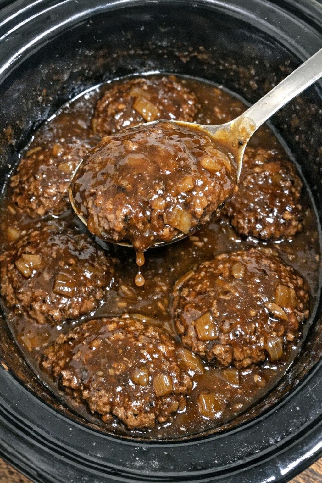 Hamburger steaks in rich brown gravy in a slow cooker