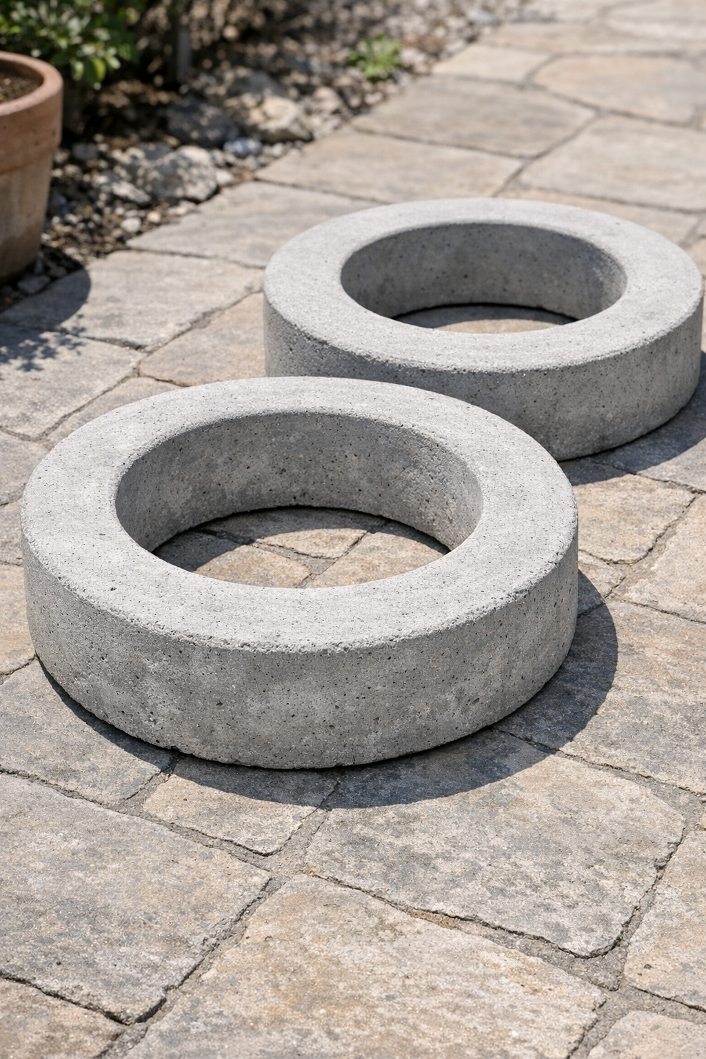 Two finished heavy cement patio rings displayed outdoors