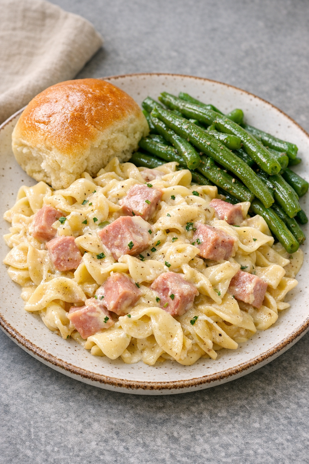 Final plated creamy ham pasta with simple sides