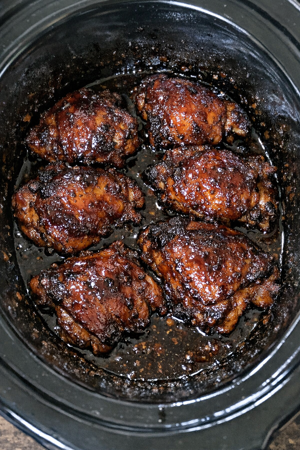 Slow cooker Amish molasses chicken in a black slow cooker