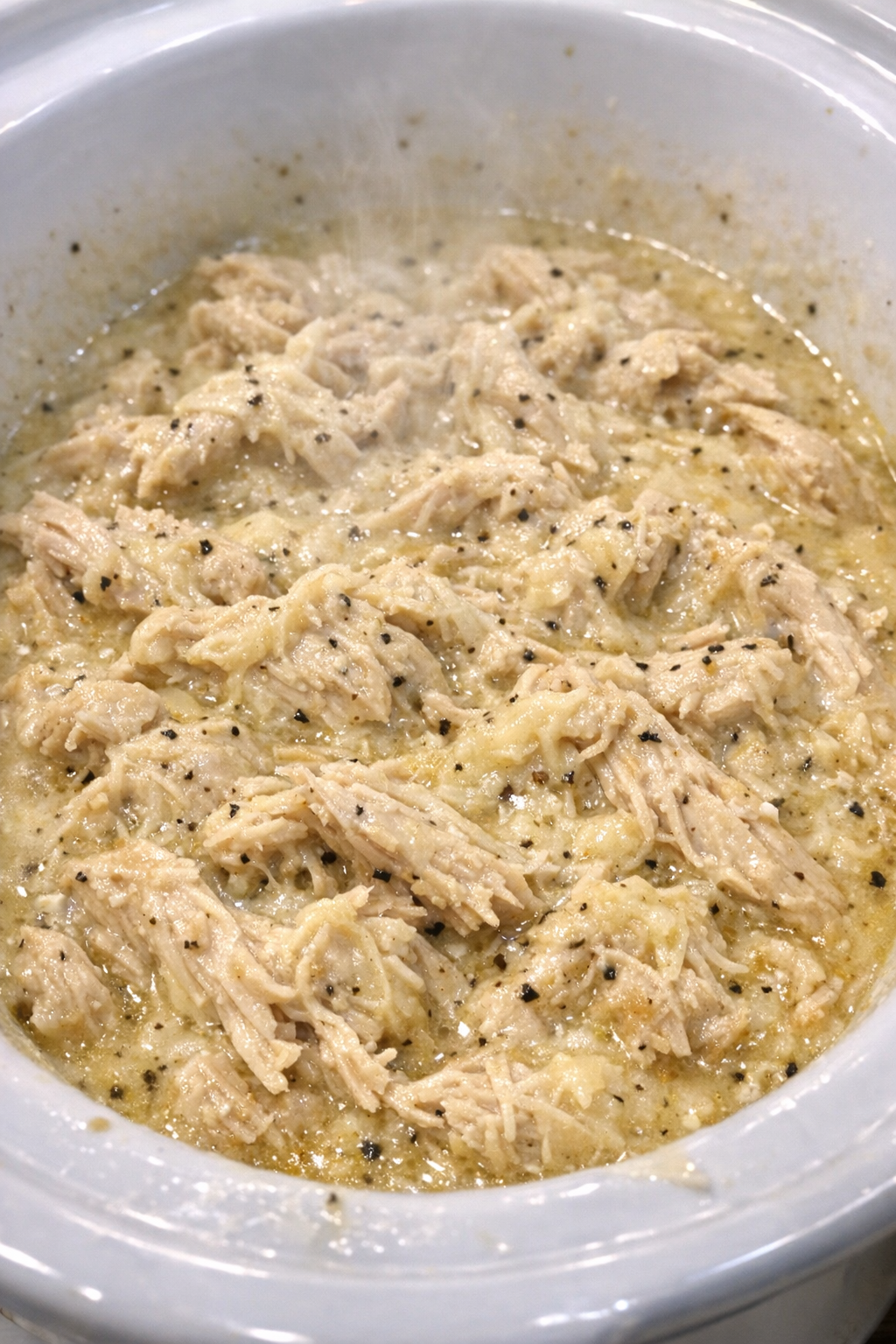 Slow cooker creamy Caesar chicken in a white slow cooker