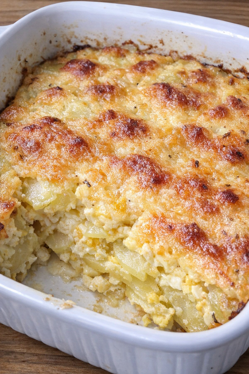 Sliced potato and baked egg casserole in a white dish