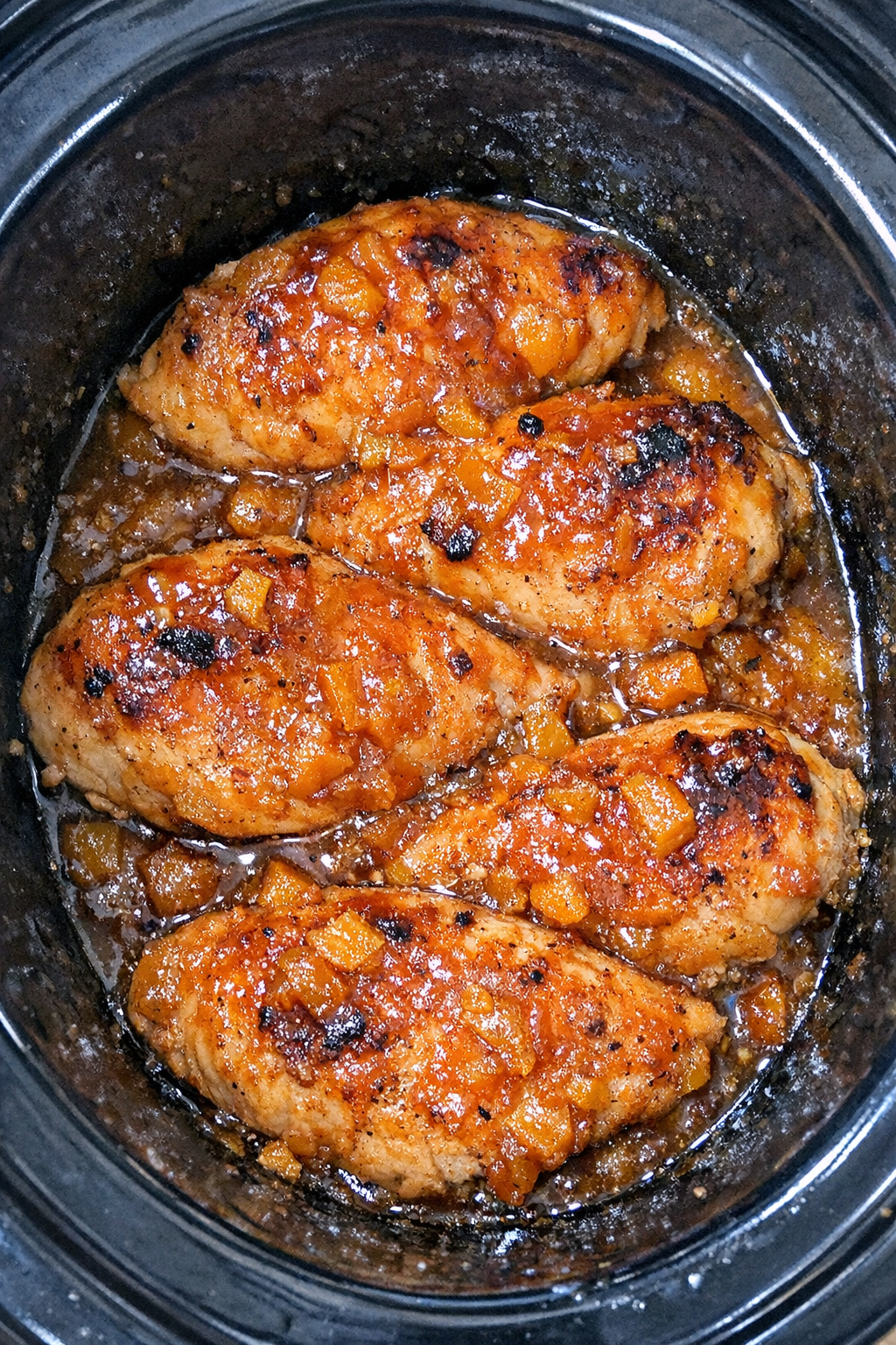 Slow cooker apricot chicken in a black slow cooker