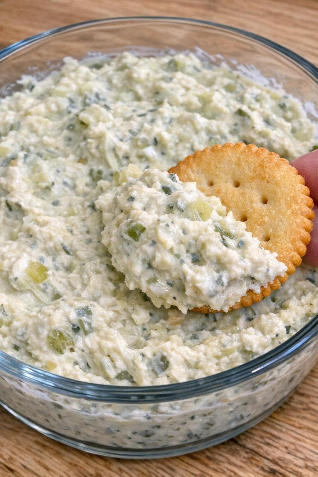 3-ingredient pickle montgomery dip in a glass bowl with a cracker scooping dip
