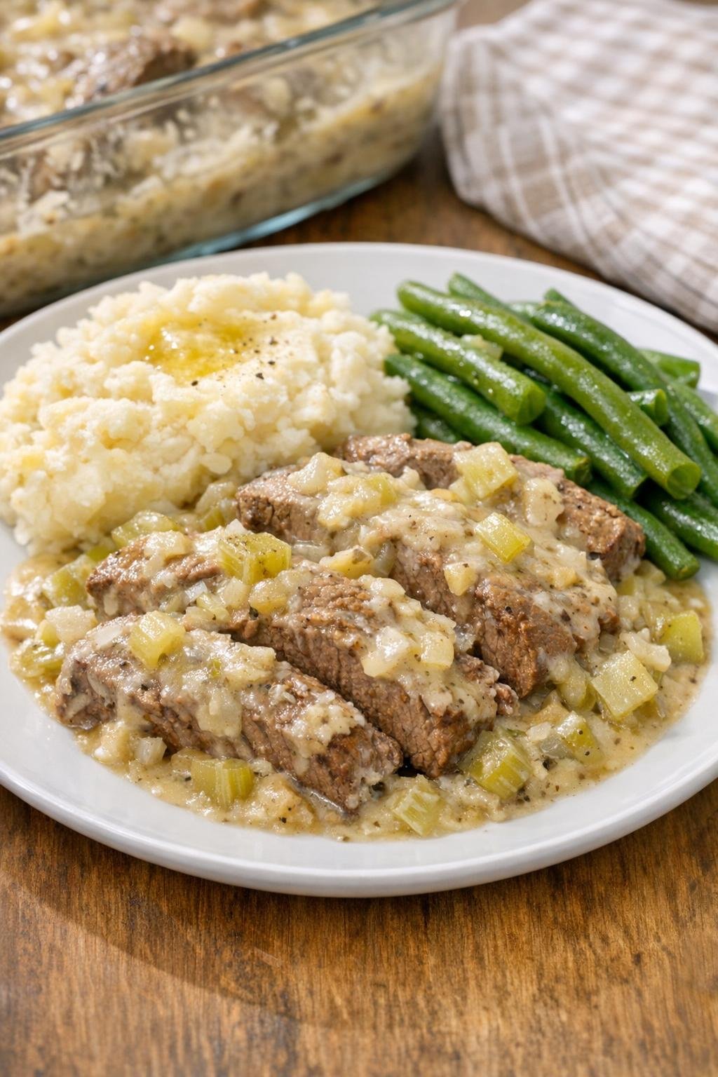 Finished baked sirloin tip steak with creamy celery sauce on a dinner plate