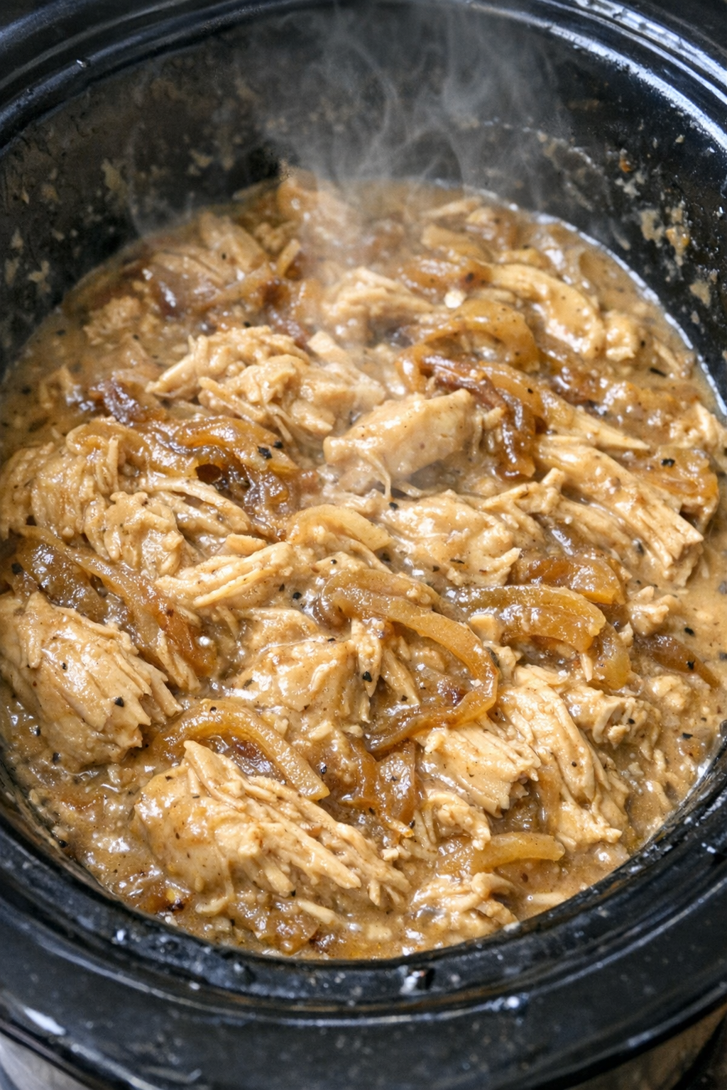 Slow cooker creamy French onion chicken in a black slow cooker