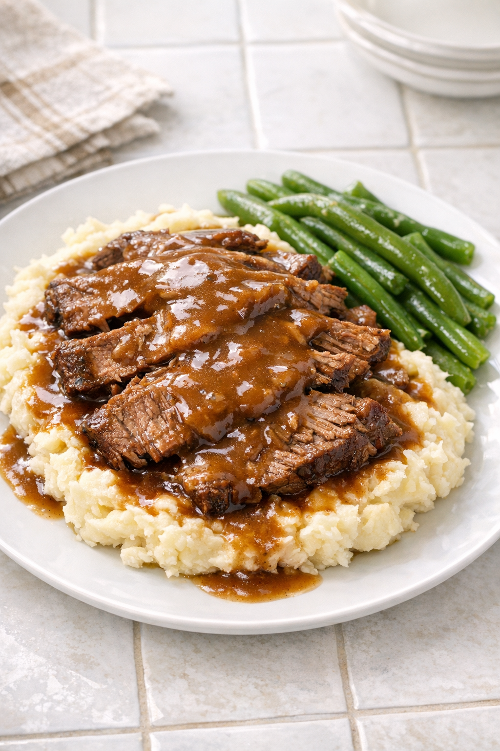 Finished brown gravy beef plated with mashed potatoes