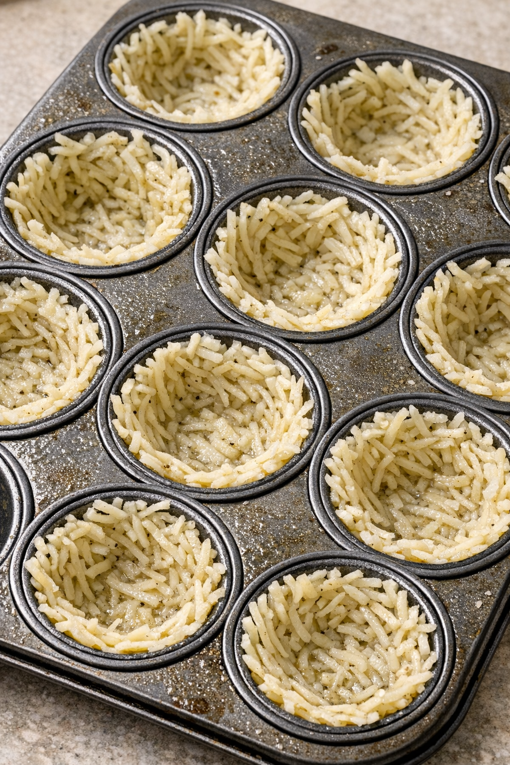 Potato mixture pressed into a greased muffin tin