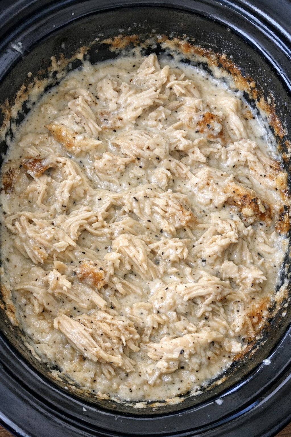Slow cooker Amish buttermilk chicken in a black slow cooker