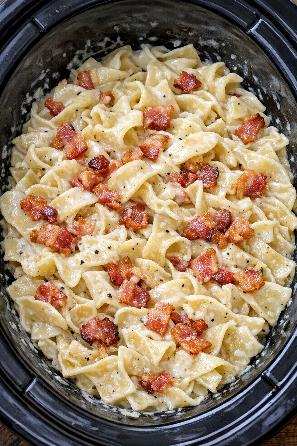 Creamy bacon noodles in a black slow cooker
