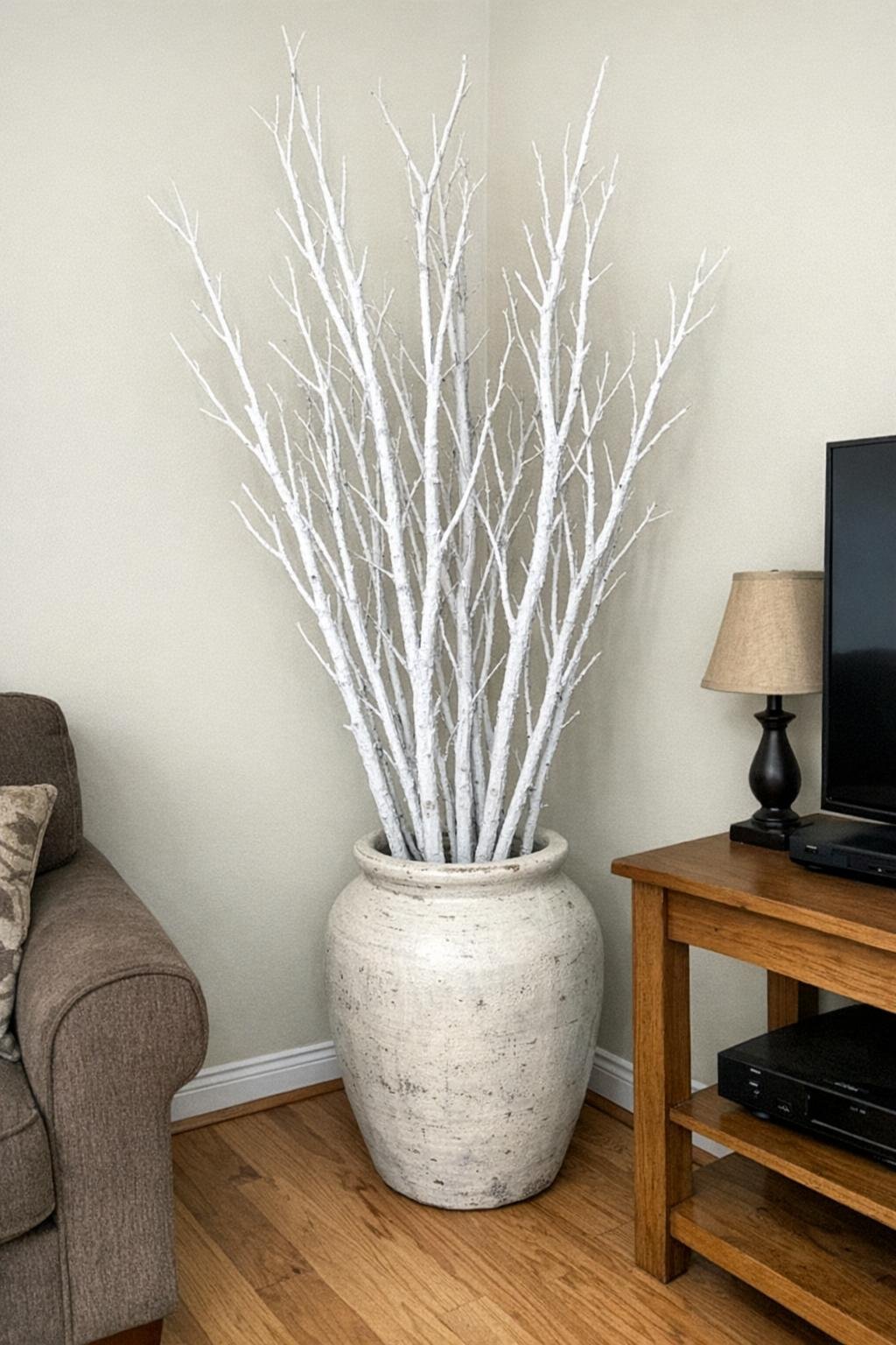 White spray-painted branches in a tall floor vase
