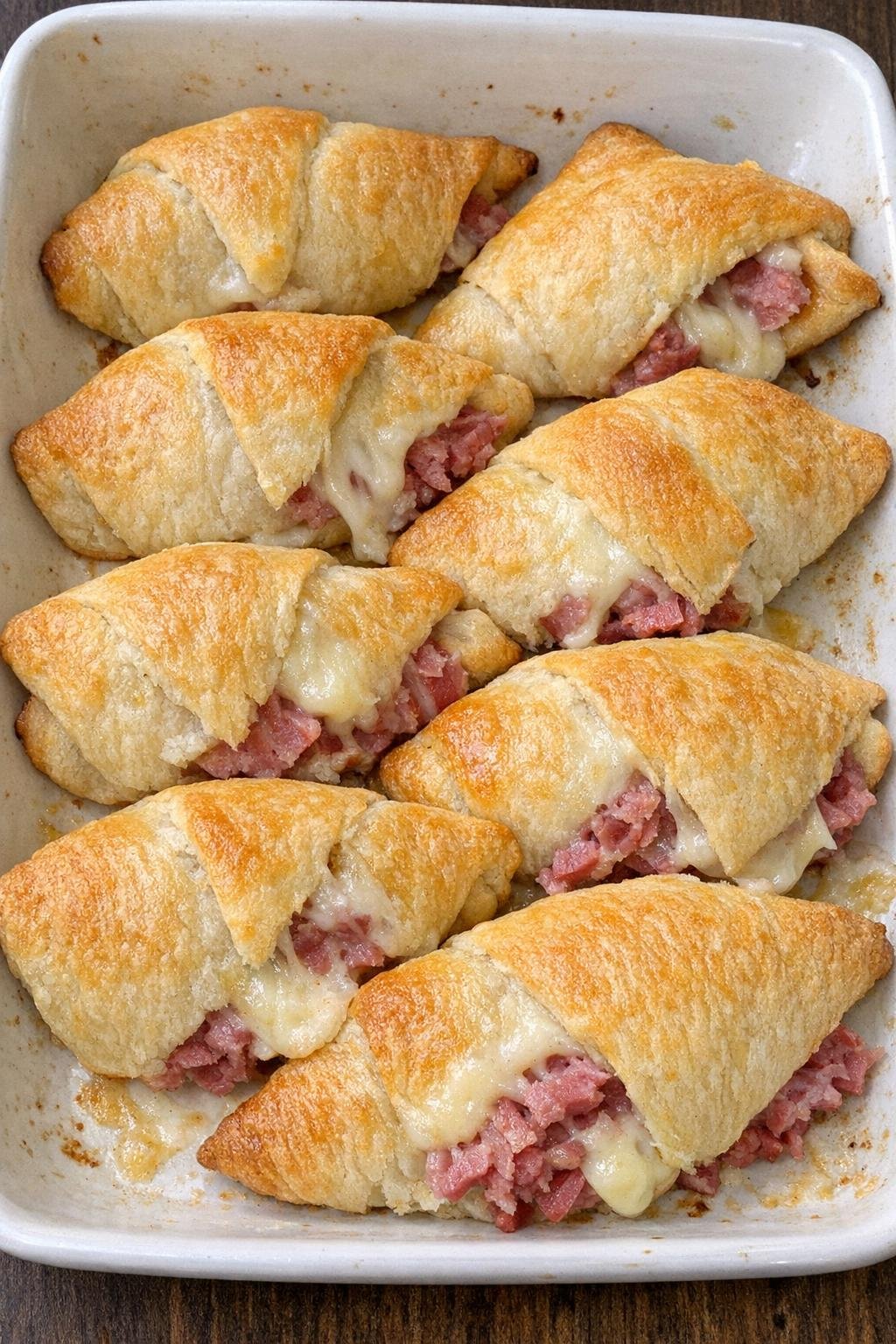 Flaky golden crescent triangles stuffed with corned beef and melted Monterey Jack cheese in a baking dish