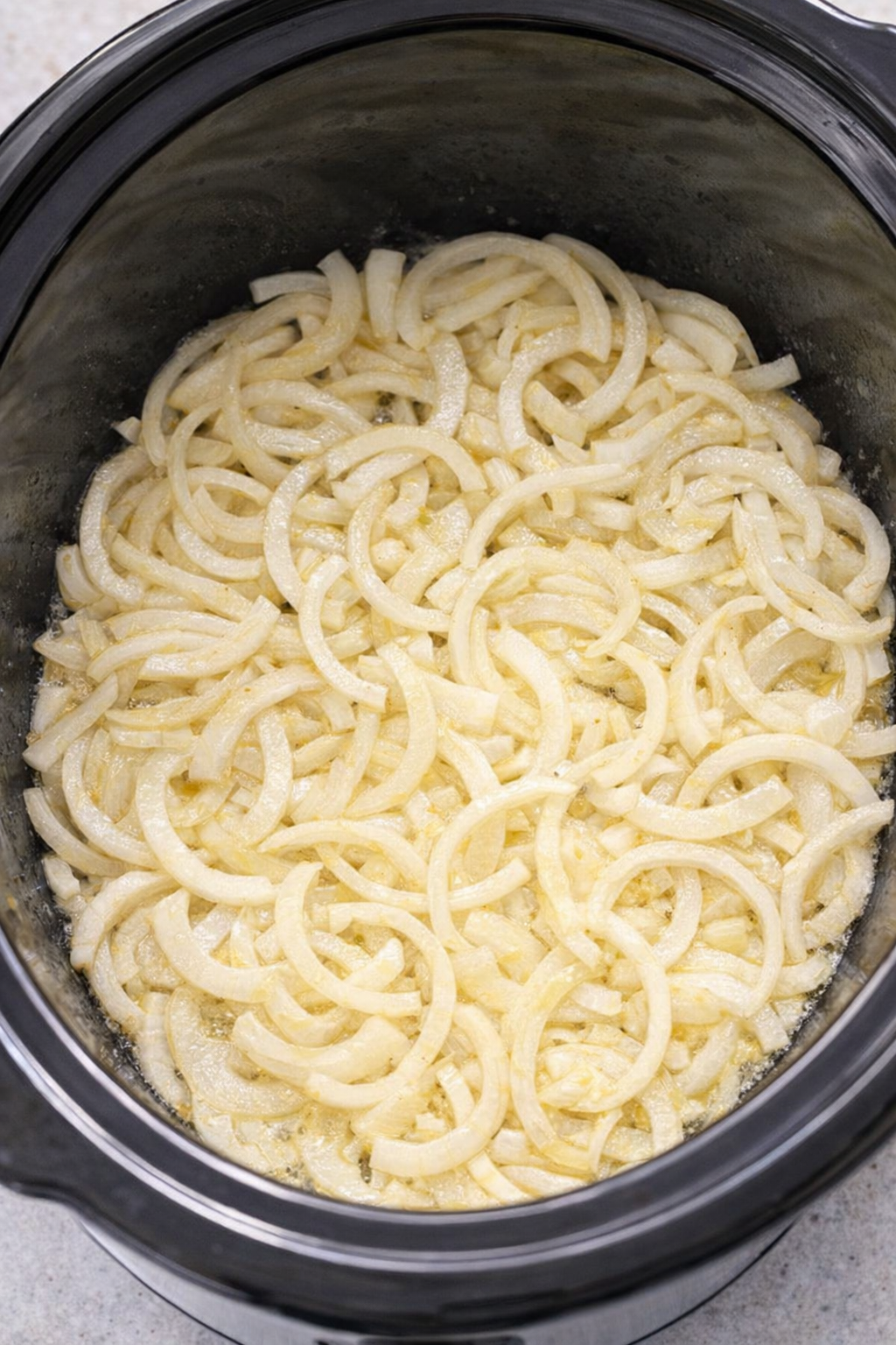 Sliced onions layered in a slow cooker