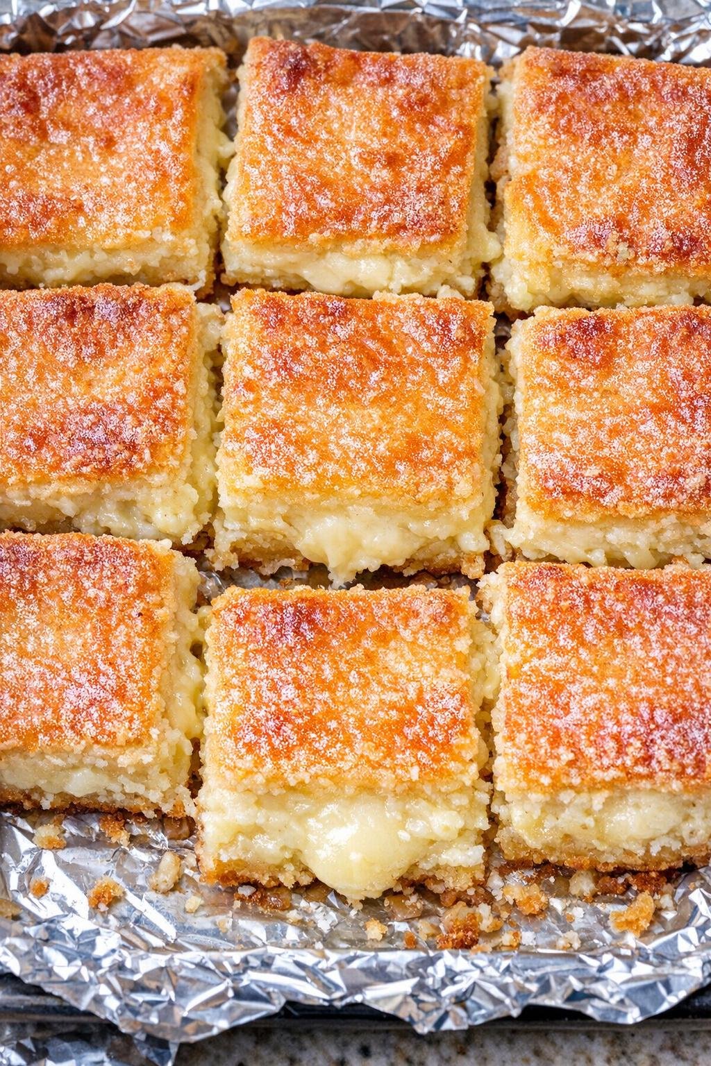 Southern 3-ingredient golden cream cheese squares on a foil-lined baking tray