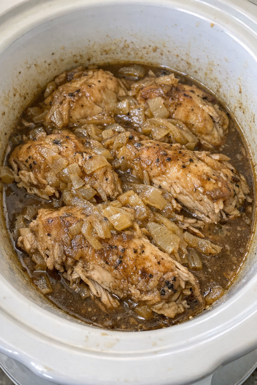 Slow cooker Amish onion soup chicken in a white slow cooker