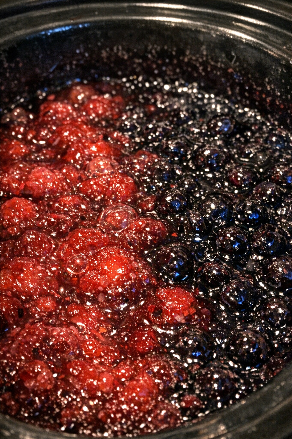 Crimson and cobalt fruit bake bubbling in a slow cooker