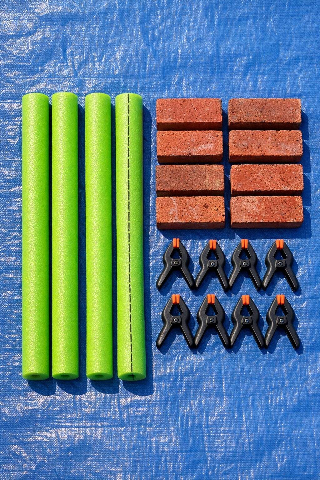 Materials for a pool noodle garden bed cover anchor laid out on a tarp