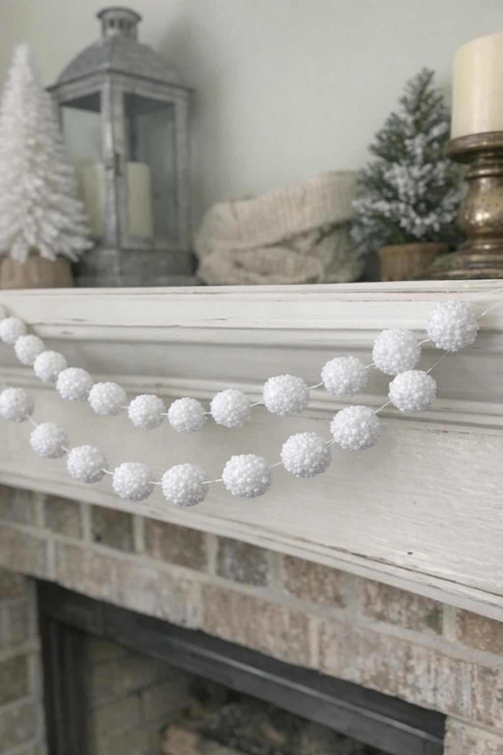 Faux snowball garland draped on a mantel