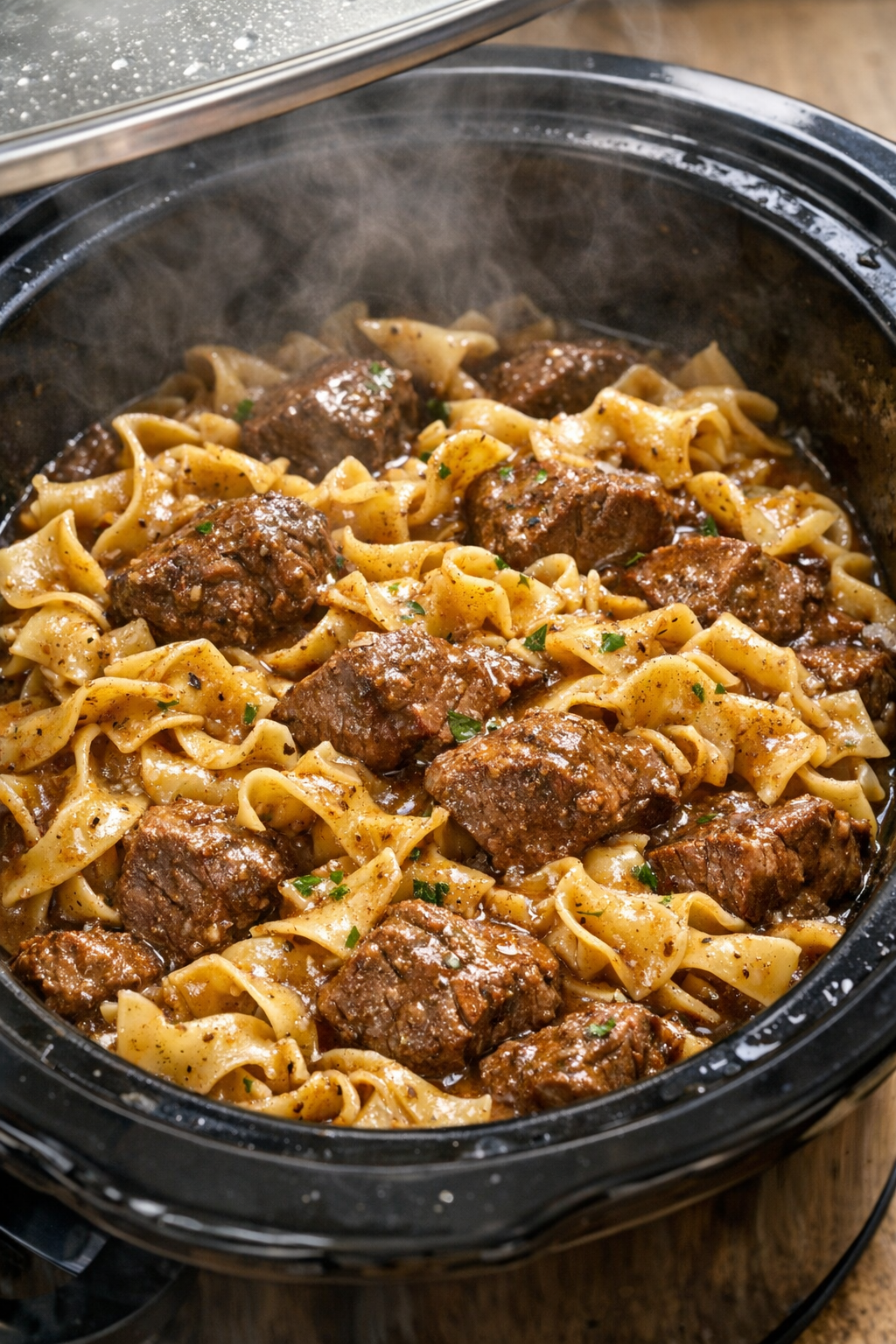 Cooked beef and noodles in rich gravy inside the slow cooker
