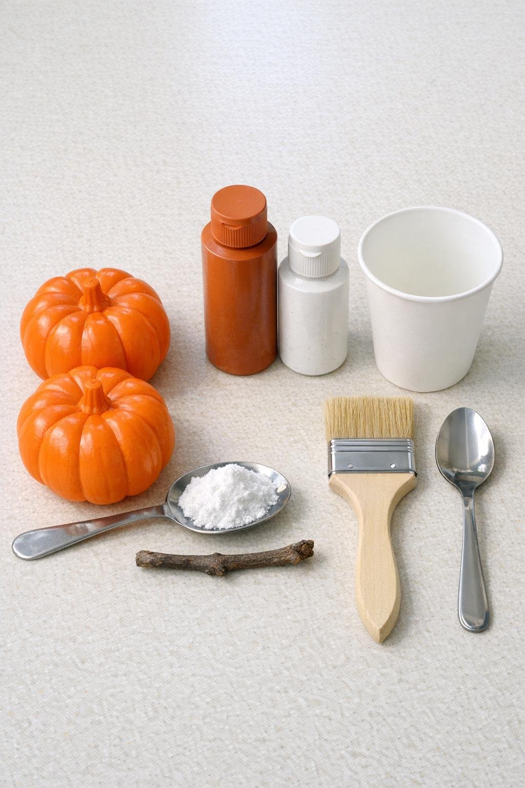 Dollar store pumpkins, paints, baking soda, and tools laid out for the project