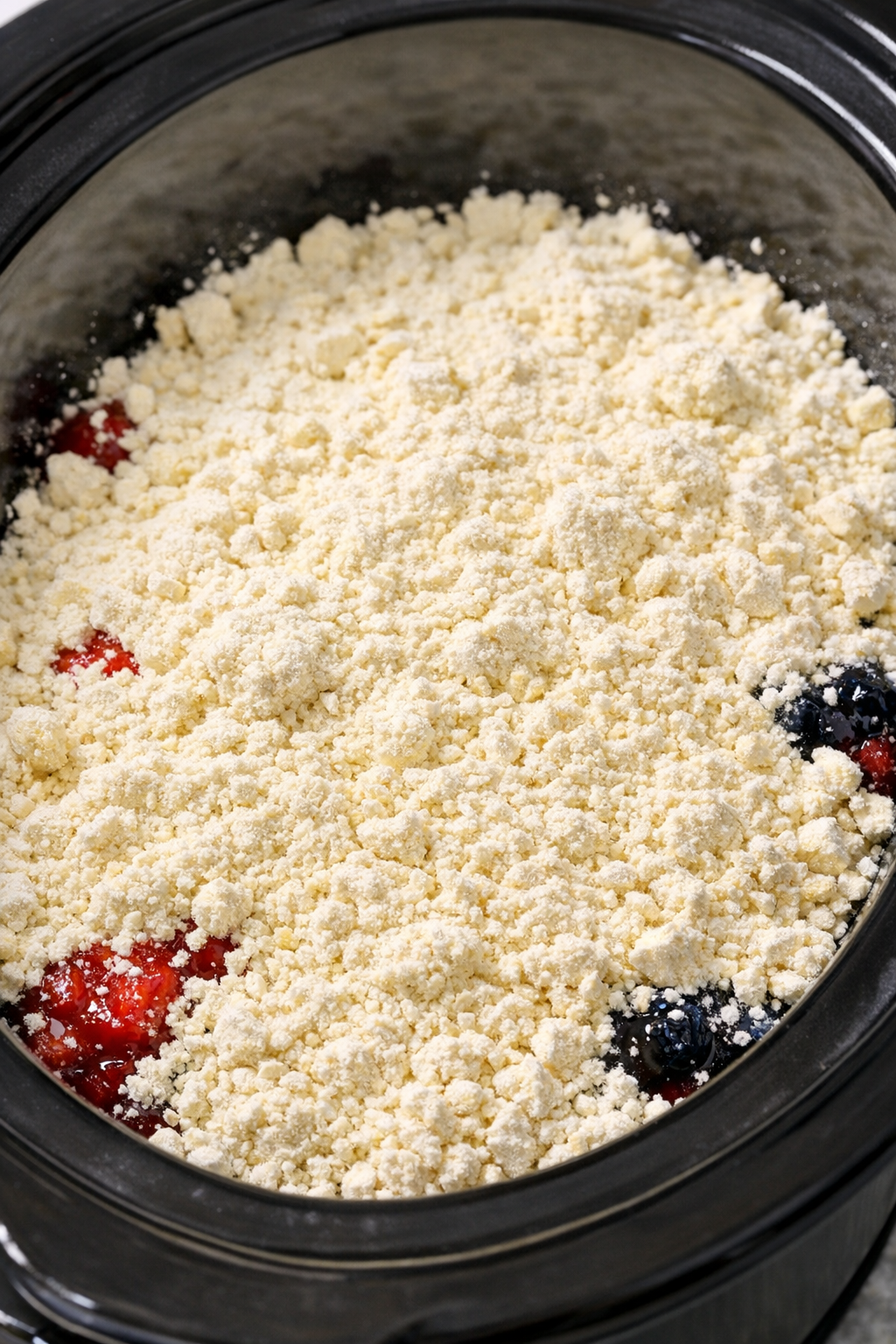 Dry cake mix covering fruit filling in the slow cooker