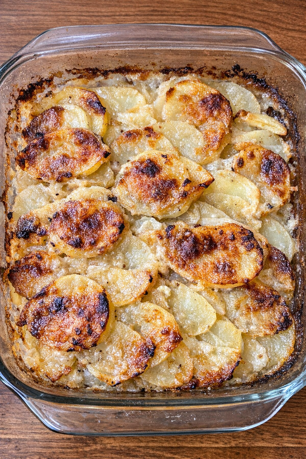 Layered parsnip and potato casserole with golden browned edges in a glass baking dish