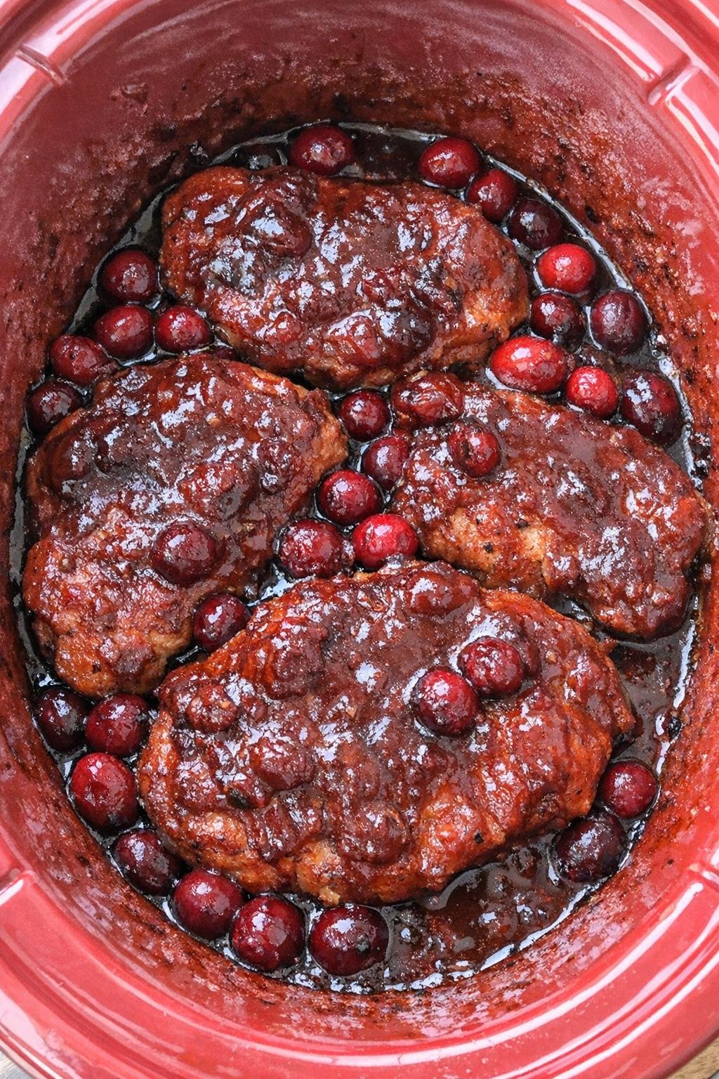 Slow cooker cranberry BBQ pork chops in a red slow cooker