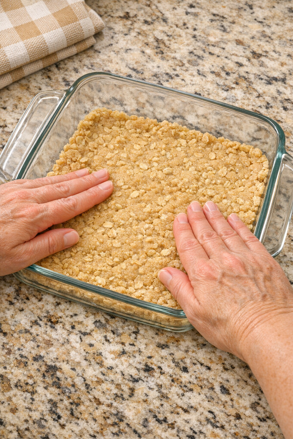 Oatmeal cookie dough pressed into a glass baking dish