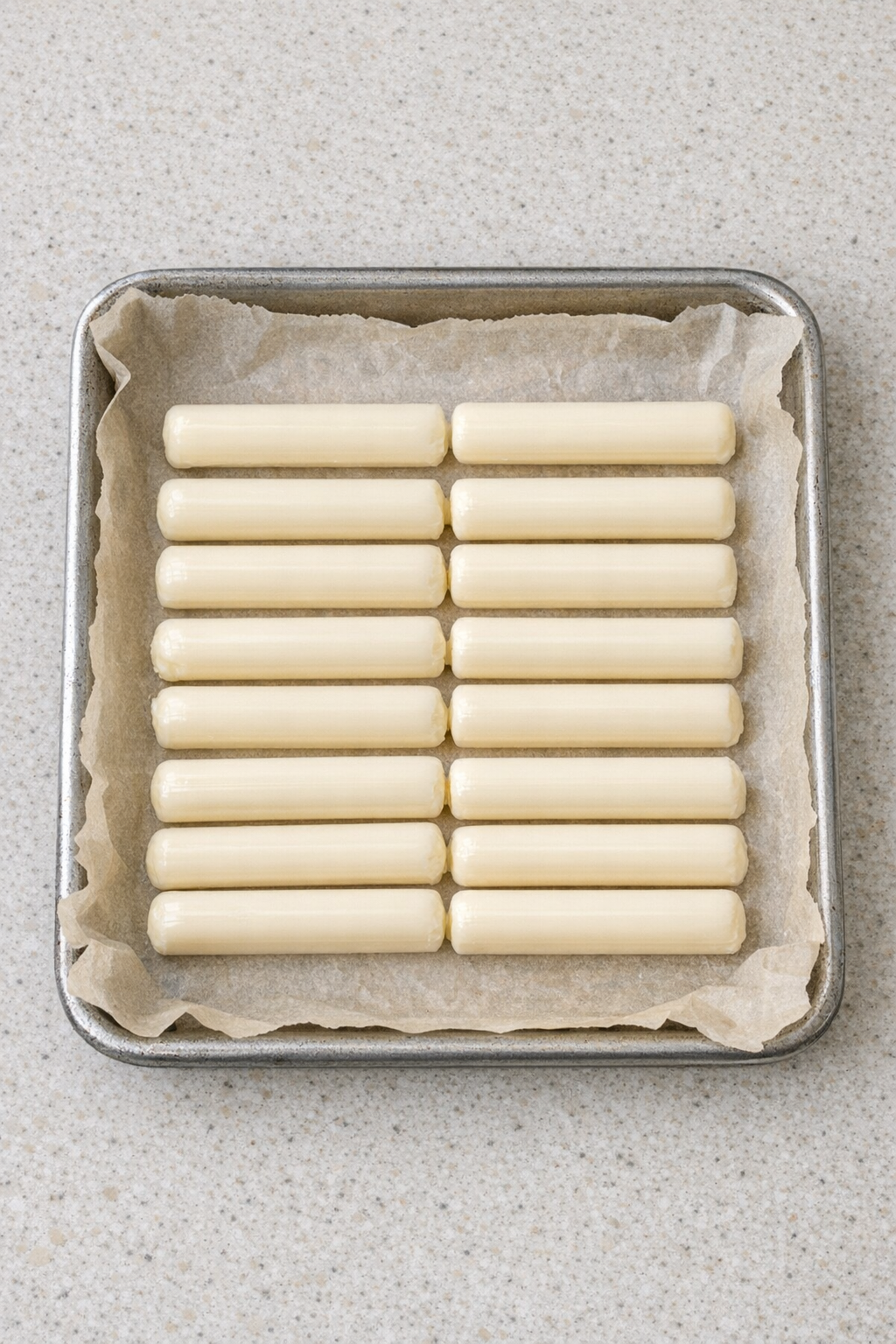 Prepared sheet pan with mozzarella string cheese sticks