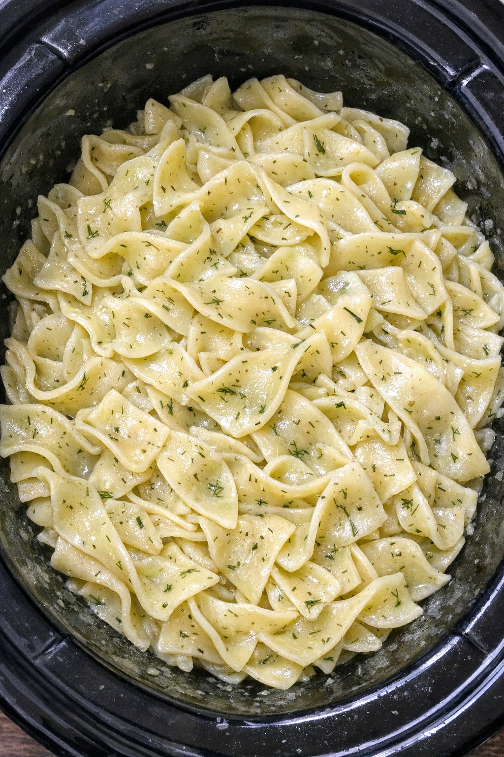 Slow cooker Amish pickle juice noodles in a black slow cooker
