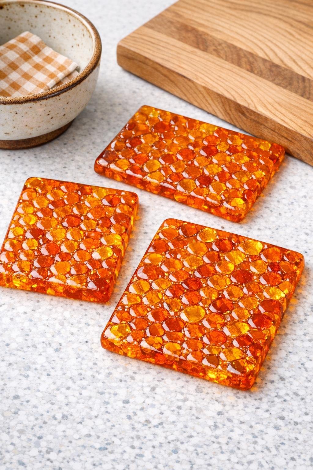 Three finished amber-style trivets made from melted orange pony beads