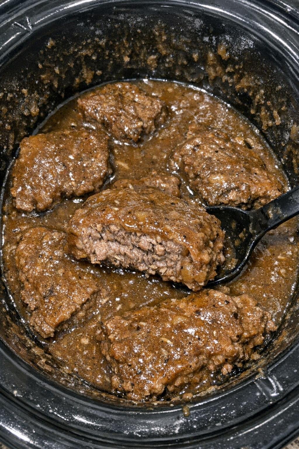 Tender cube steak in brown gravy in a slow cooker insert