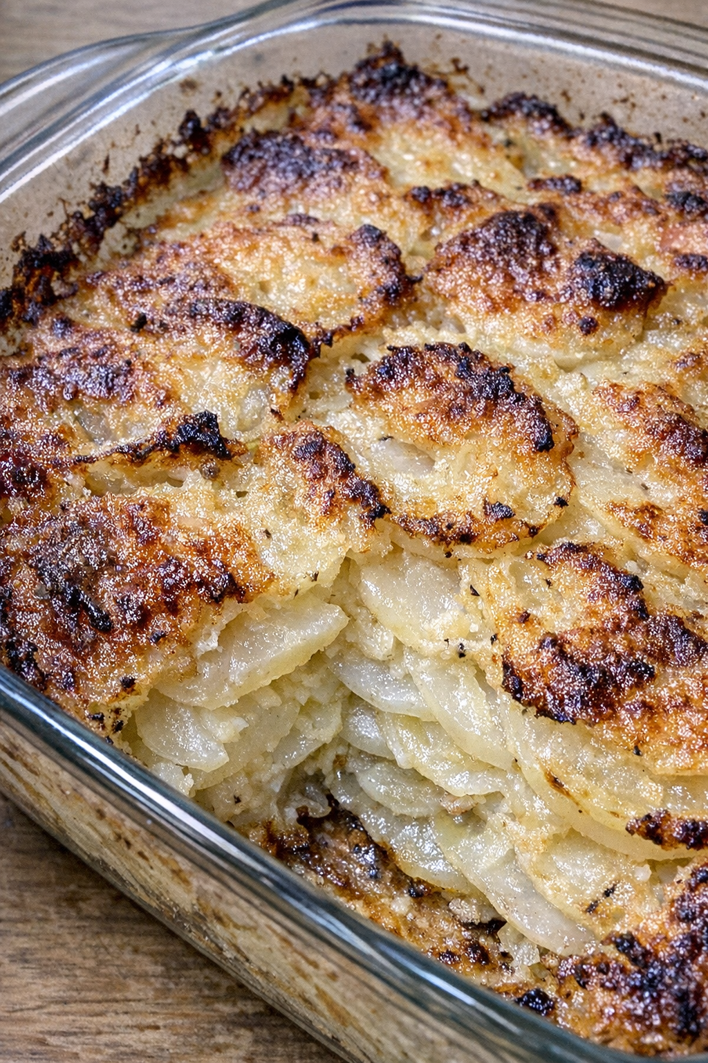 Layered turnip and potato casserole with golden edges in a glass baking dish
