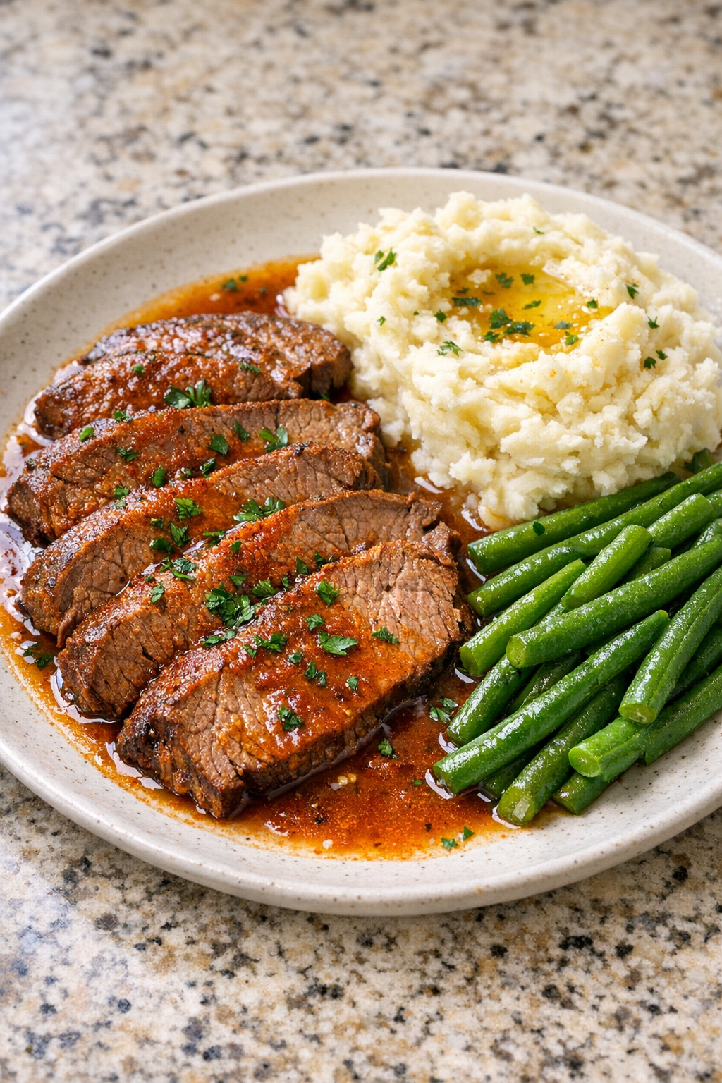 Finished Amish paprika beef plated with mashed potatoes and green beans