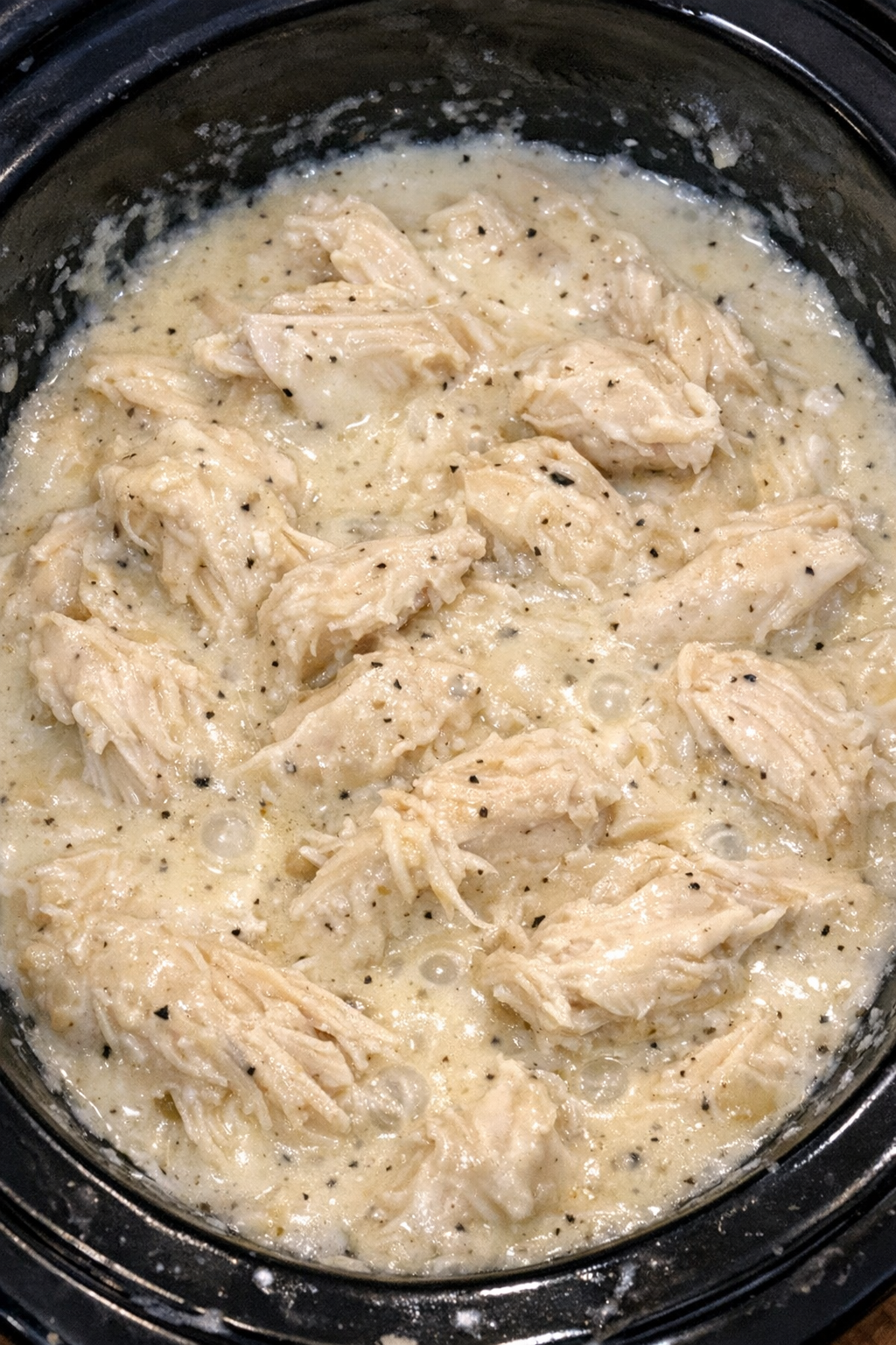 Slow cooker cream cheese chicken in a black slow cooker