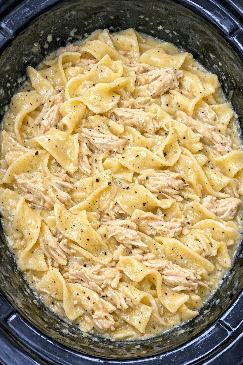 Slow cooker chicken and egg noodles in black slow cooker