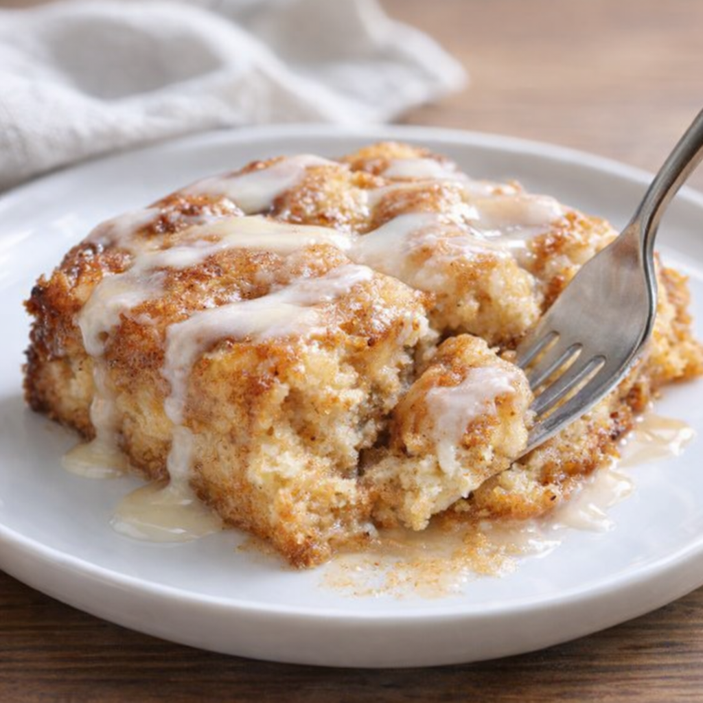 Warm serving of cinnamon roll casserole with icing drizzle