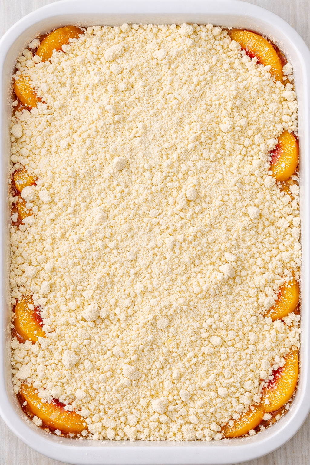 Dry cake mix sprinkled over peach filling