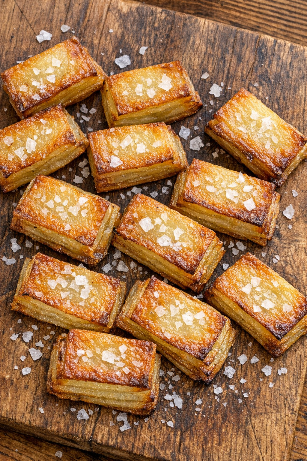 Crispy potato dominos on a rustic wooden board