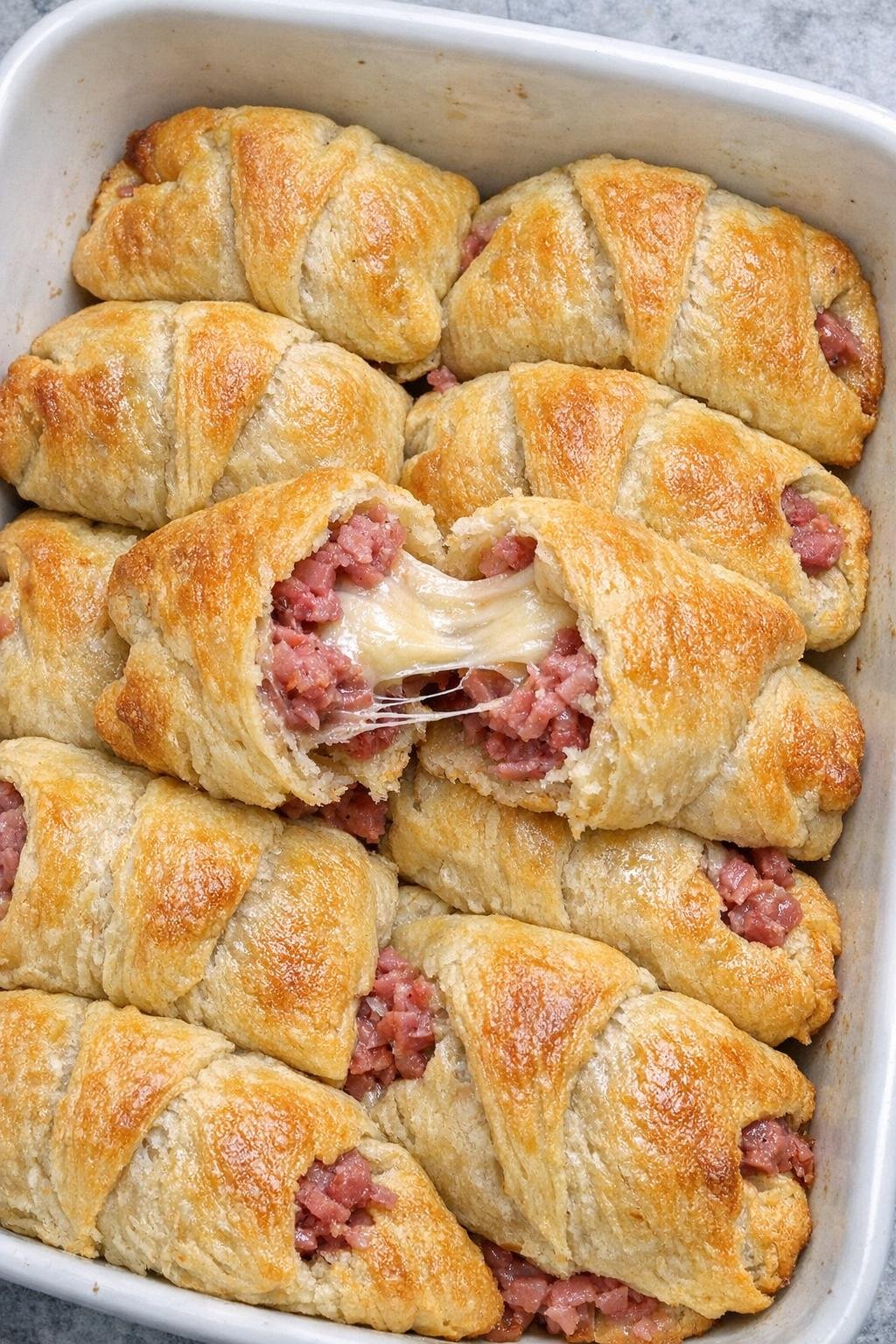 Golden flaky crescent pouches with corned beef and melted raclette cheese