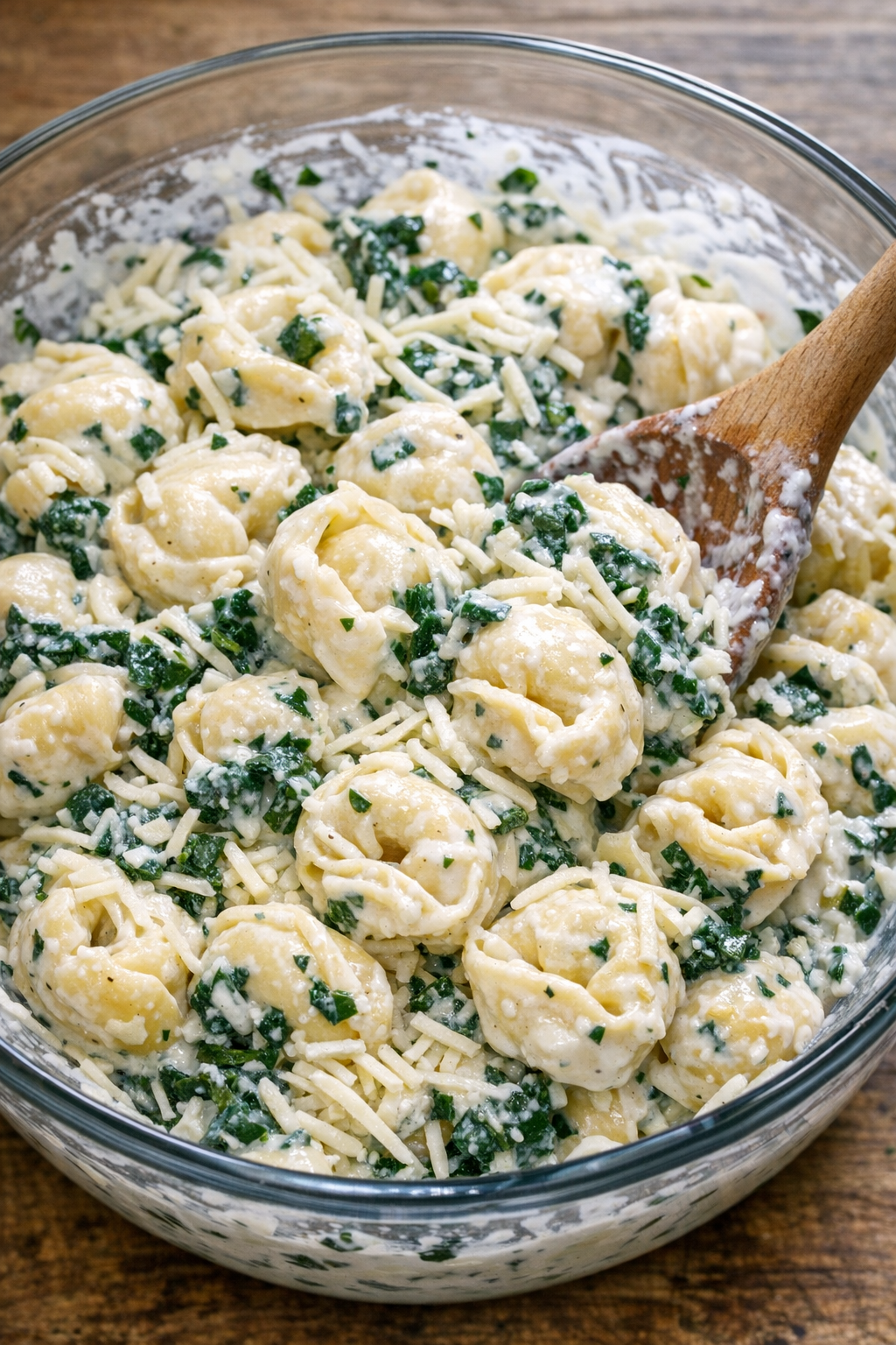 Tortellini, špinatai, Alfredo padažas ir sūris sumaišyti dubenyje