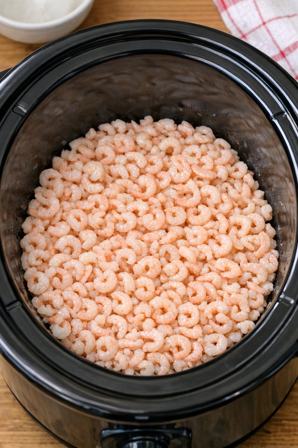 Tiny shrimp spread in the bottom of a slow cooker