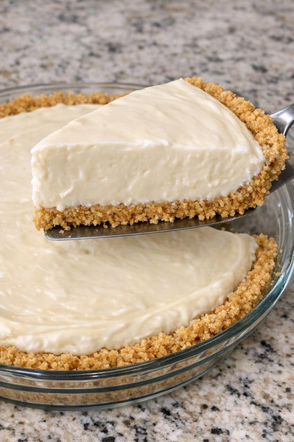 Close-up of a creamy no-bake cheesecake with one slice lifted