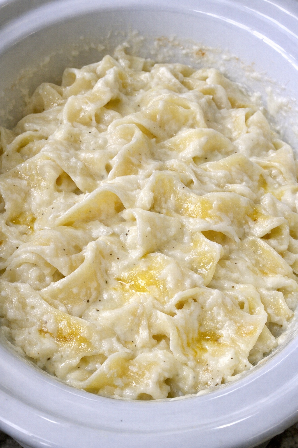 Slow cooker Amish cream cheese noodles in a white slow cooker