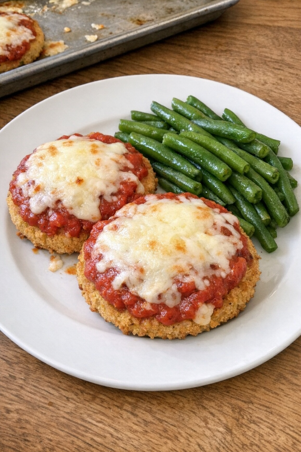 Baked chicken patties topped with sauce and melted cheese