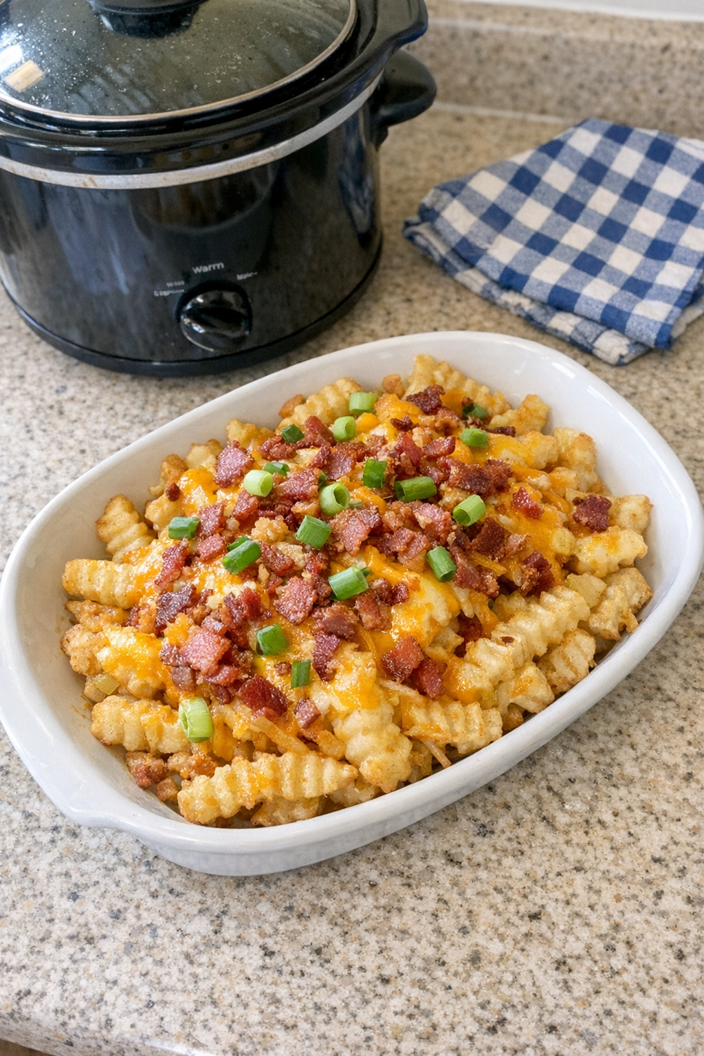 Finished cheesy slow cooker potatoes made from crinkle cut fries